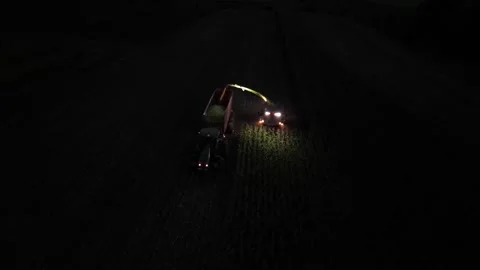 Green combine chopping corn silage in Ukraine at night Stock Footage 298052116