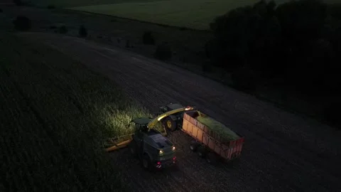 Green combine chopping corn silage in Ukraine at night Stock Footage 298065570
