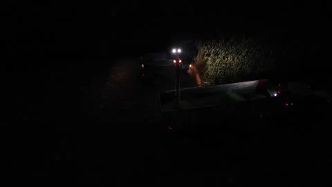 Green combine chopping corn silage in Ukraine at night Stock Footage 298071544