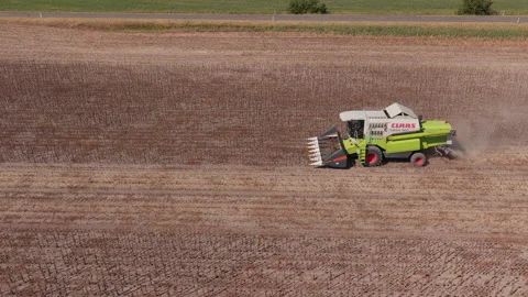 Green combine working dry stubble land, Rural Hungary Drone Track Vídeos de archivo 346340232