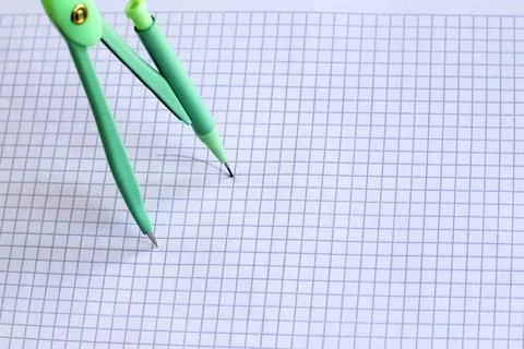 Green compass draws a circle on notebook Stock Photos