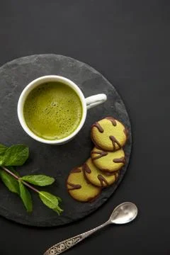 Green composition with match tea and cookies for healthy breakfast Stock Photos