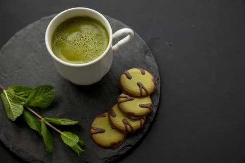 Green composition with match tea and cookies for healthy breakfast Stock Photos