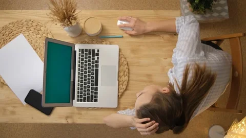 Green computer screen. The girl lies at the table and remotely learns, works. Su Vídeos de archivo 148547016