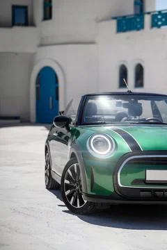 Green convertible car front side view near white building Stock Photos