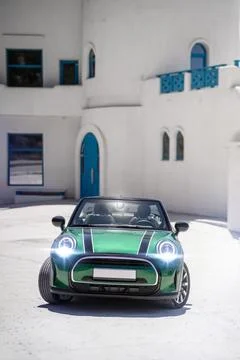 Green convertible car front view near Mediterranean building Stock Photos