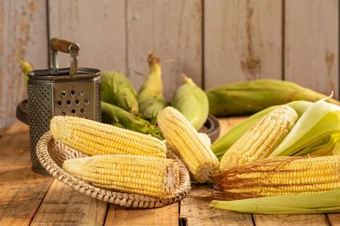Green corn, green corn cobs and accessories on a rustic wooden table, selec.. Foto stock