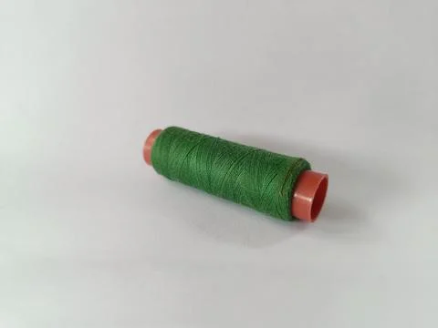 Green cotton thread roll. White background. Stock Photos