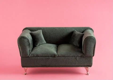 Green couch on pink background. Stock Photos