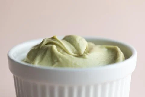Green cream cake muslin in white ramekin on a beige background Stock Photos