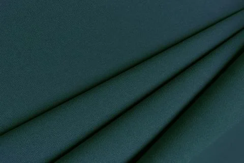 Green crumpled or wavy fabric texture background. Abstract linen cloth soft Stock Photos