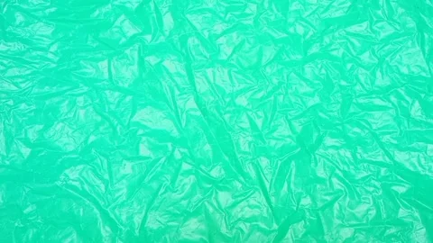 Green crumpled plastic bag texture background rotating. HDPE Polyethylene Stock Footage 316378829