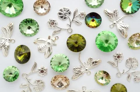     Green  crystals and metal bees and flowers and dragonflies on white ba 库存照片