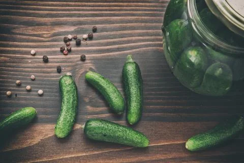 Green Cucumbers, Back and Red Pepper on the Wooden Table Stock Photos