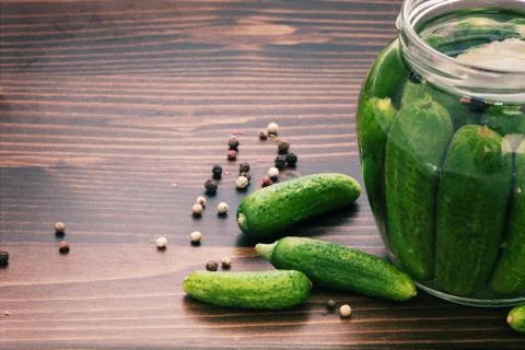Green Cucumbers, Back and Red Pepper on the Wooden Table Stock Photos