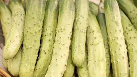Green cucumbers in a basket on a shelf in store close-up top view. Stock Footage 274038278
