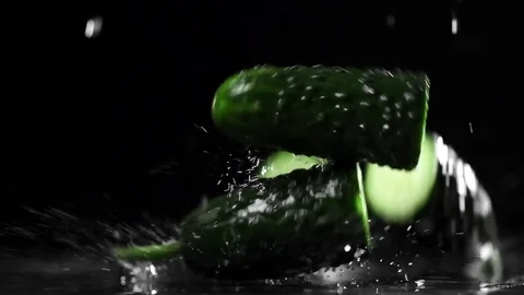 Green cucumbers fall and split into halves in slow motion, food in super slow Stock Footage 83175909