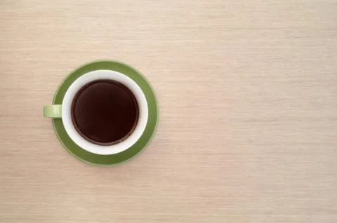 Green cup of coffee on the background of the table. View from top Stock Photos