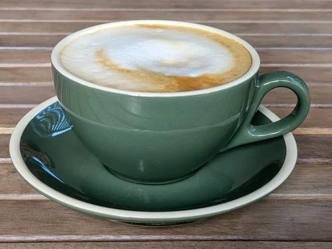 Green cup of hot coffee on the table Stock Photos