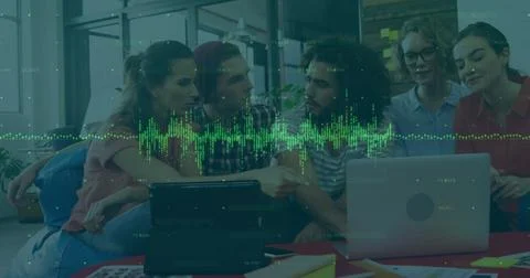 Green data visualization image over diverse team collaborating on laptop in Stock Photos