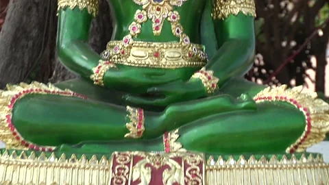 A green deity in a Thai temple and flowers under his feet Stock Footage 149234033