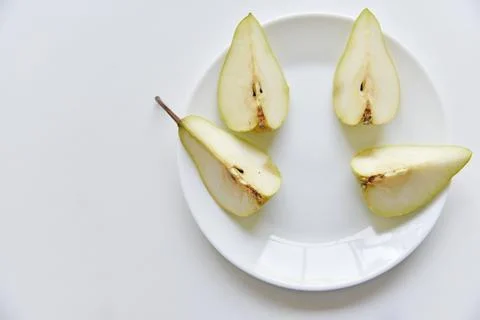 Green delicious pears on a white plate close-up Stock Photos