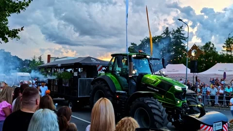 Green DEUTZ-FAHR tractor pulling a VAKS trailer at the Valmiera city festival Stock Footage 327689968
