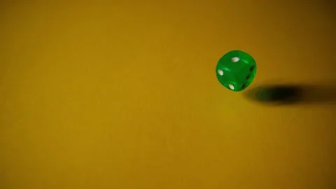 Green dice fall in slow motion at yellow paper background. Cardboard background Video stock 288769750