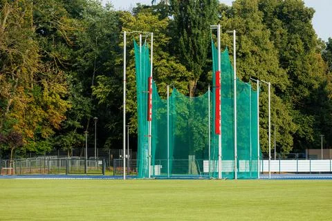 Green discus and hammer throwing cage with protective net at an empty athle.. Stock Photos
