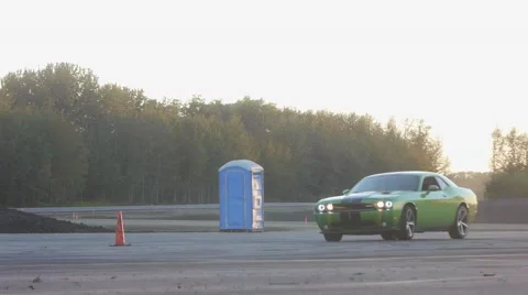 Green dodge challenger cruises on closed course at sunset. Stock Footage 59761981