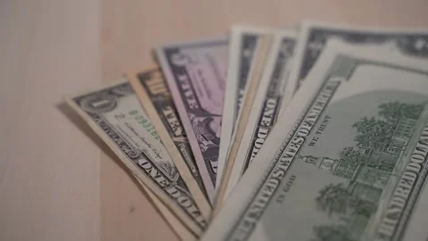 Green dollar bills slowly falling in a stack on a wooden background, banknotes 库存影片 147537798