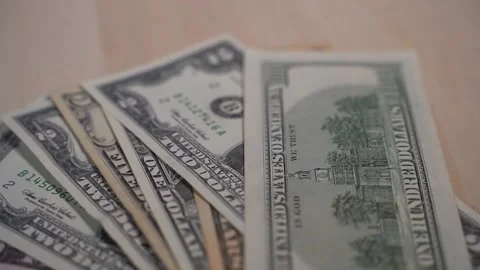 Green dollar bills slowly falling in a stack on a wooden background, banknotes 库存影片 147537848