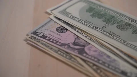 Green dollar bills slowly falling in a stack on a wooden background, banknotes 库存影片 147537871
