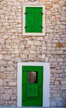 Green door and window shutters in Croatia Stock Photos