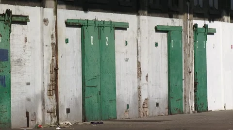 Green doors + zoom out loading platforms and storage compartments warehouse Stock Footage 49097069