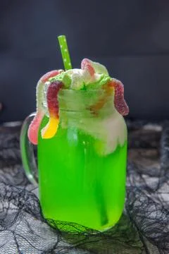 Green drink with ice cream float and gummy worms for Halloween Stock Photos