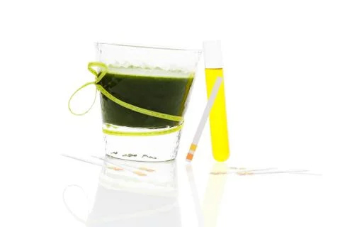 Green drink, ph test strips and urine in test tube. Stock Photos