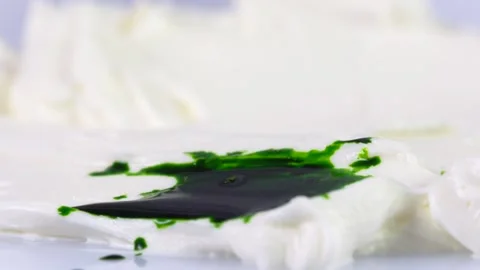 The green drop is falling on cream. Stock Footage 130852210