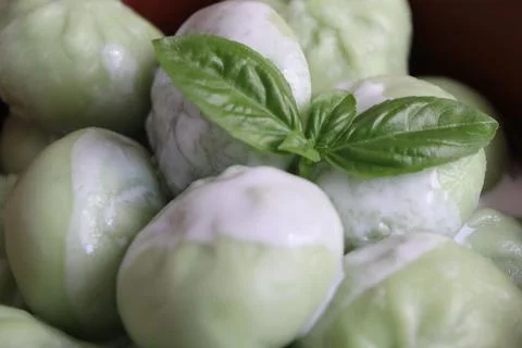 Green dumplings with a basil leaf on top in a close-up view Stock Photos
