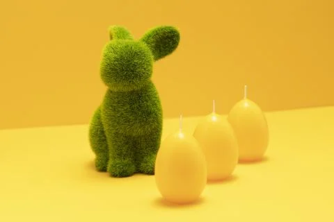 Green Easter Bunny with three yellow candles of eggs shape on matching Stock Photos