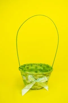 Green, Easter, children's basket empty, wicker on a yellow background Stock Photos