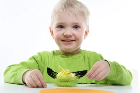 Green Easter - a little boy decorates Easter eggs  Foto stock