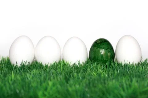 A green egg between the white eggs Stock Illustration