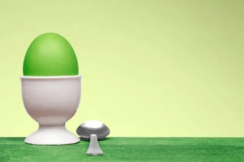 Green egg in white egg cup Stock Photos