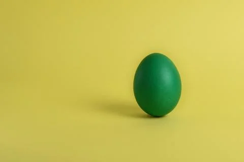 Green egg on yellow background Stock Photos