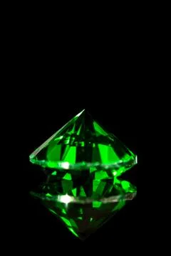 Green emerald in front of black background, flawless gem 写真素材