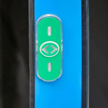 Green emergency button on the door of a train, close-up Photos