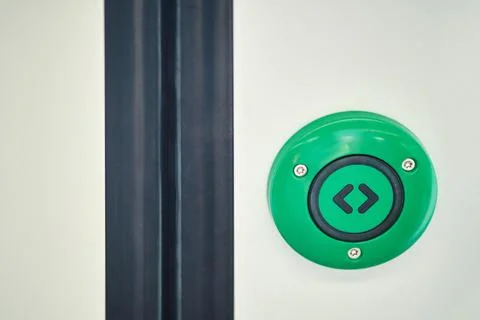 Green emergency button on the door of a train, close-up Photos