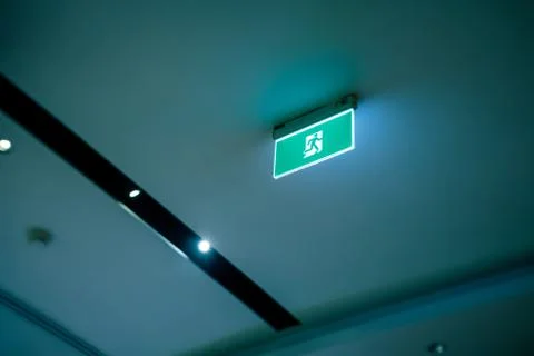 Green emergency exit or fire exit hanging sign Stock Photos
