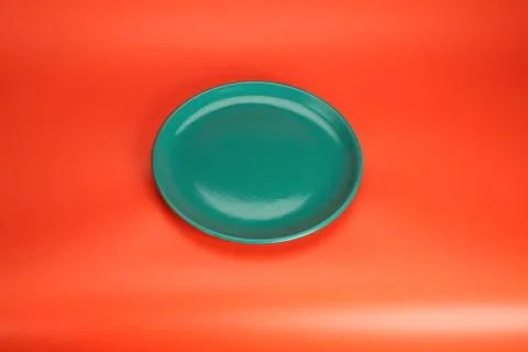 Green empty  plate on red table Stock Photos